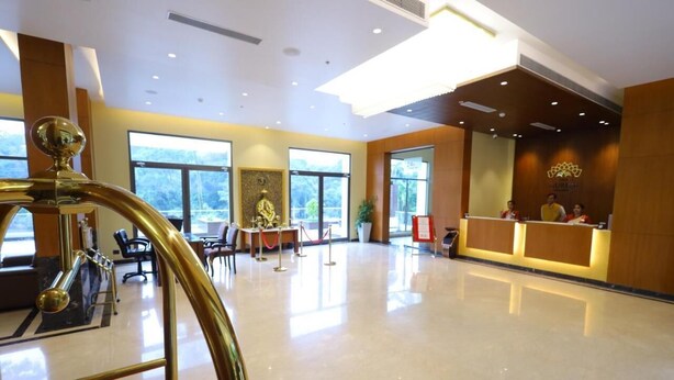 Un hall amplio con mostrador de recepción, zona de estar y una fuente decorativa.