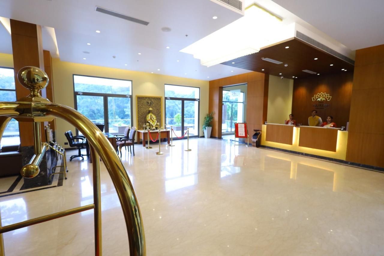 A spacious lobby with a reception desk, seating area, and a decorative fountain.