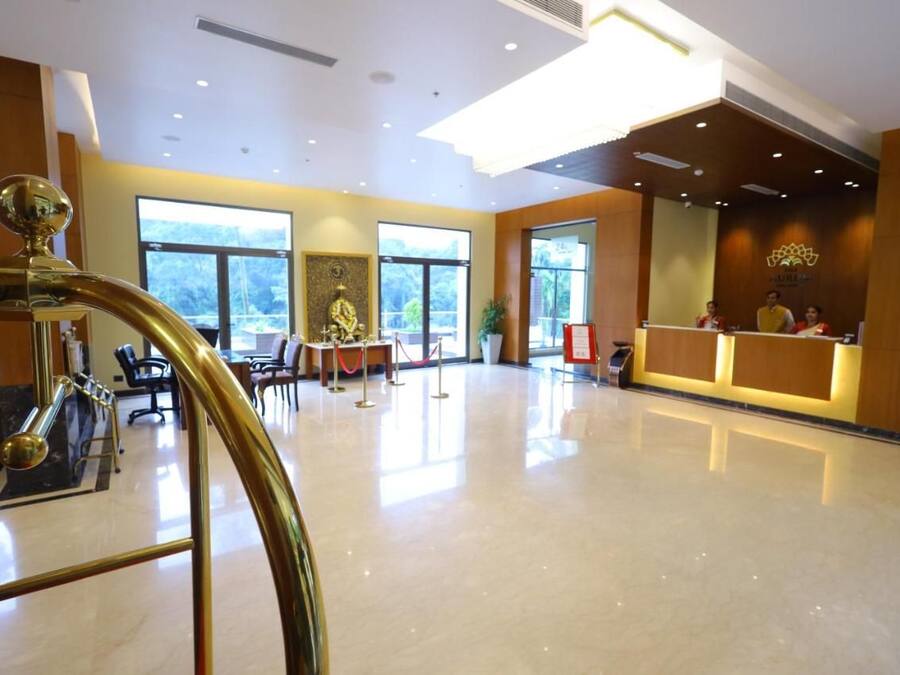 A spacious lobby with a reception desk, seating area, and a decorative fountain.