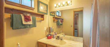 A bathroom with a sink, mirror, and towel rack.