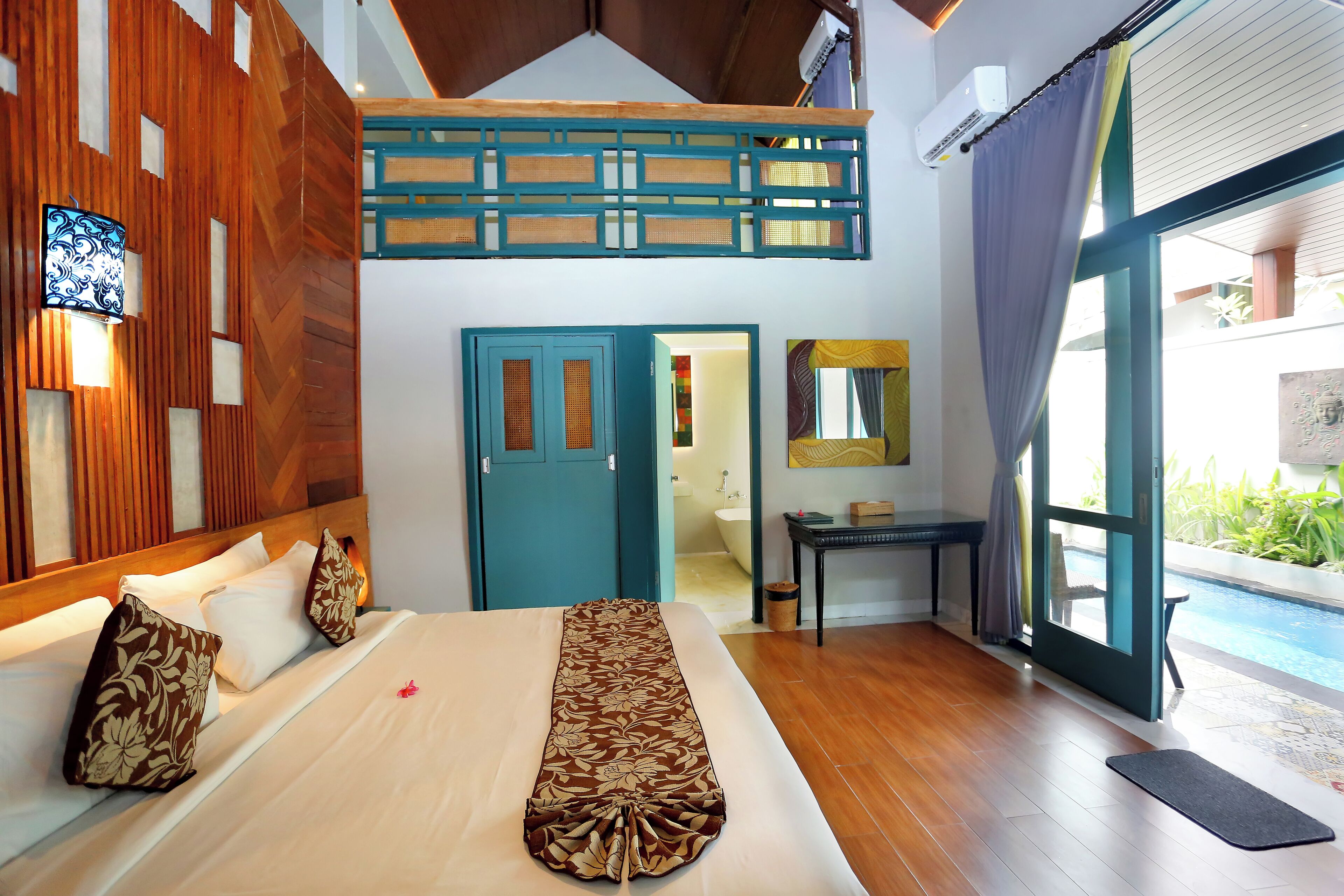 Un dormitorio con cama, paredes de madera, ventilador de techo, ventana con cortinas y vista a una piscina.