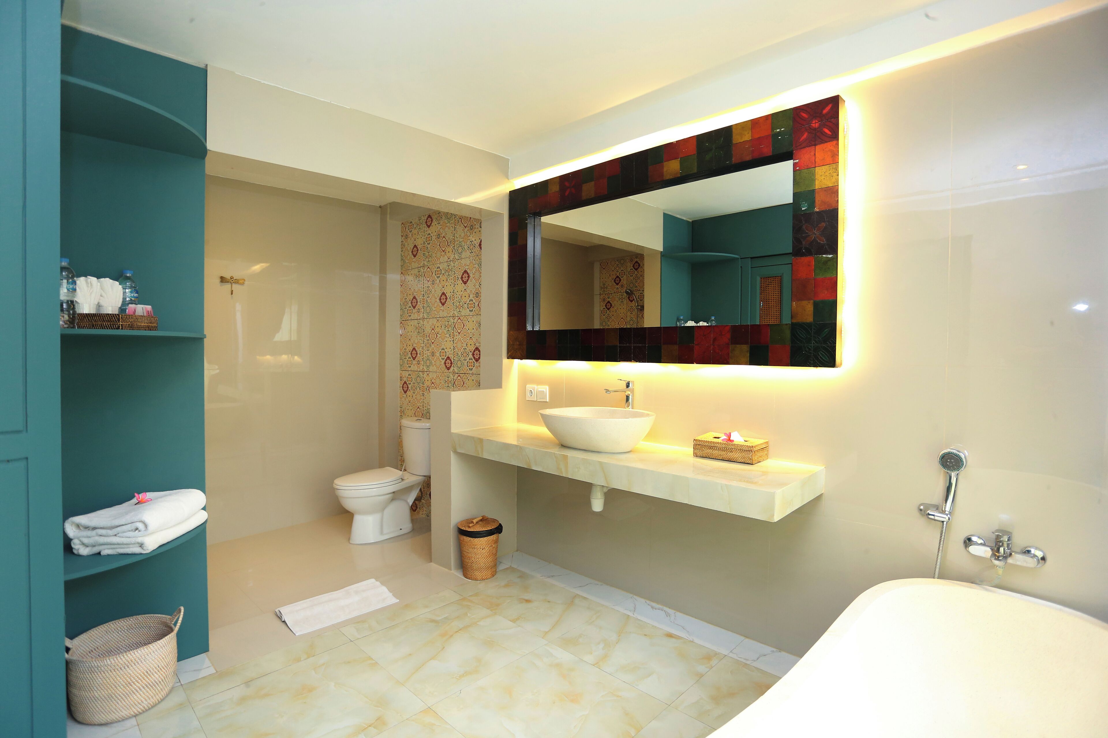 A bathroom with a white sink, a large mirror, a toilet, and a bathtub.