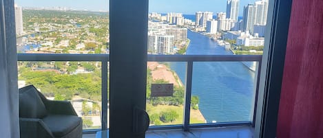 A balcony with a view of a river and cityscape, including high-rise buildings and greenery.