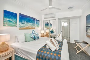 Relax in a stylish room with a large bed, seating area, and ocean-inspired artwork.