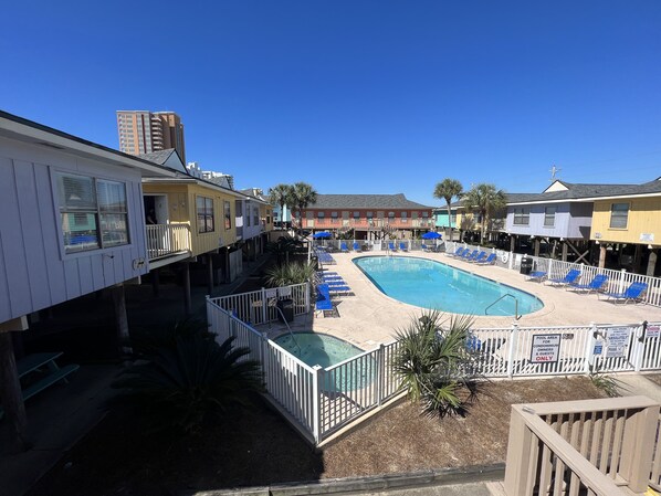 A pool area with blue lounge chairs and a sign indicating it is for owners and guests only.