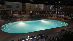 A swimming pool with a surrounding deck, lounge chairs, and a railing. - Convenient to everything! Only steps to the beach. (Gulf Shores)