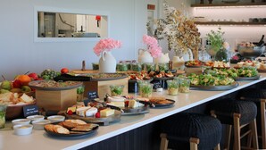 A buffet table with various food items and drinks, including fruits, cheeses, and salads. - Te Karaka Lodge (Waikaretu)