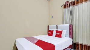 A neatly made bed with white and red bedding, two pillows with the word "OYO" on them, and a red and white striped blanket. - Hotel O Amole Paviliun Syariah (Cilacap)