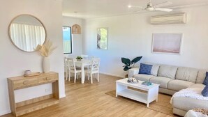 Een moderne woonkamer met een bank, salontafel en een eethoek.