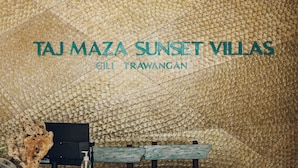 Una habitación con pared texturizada, una mesa de madera y tres taburetes de madera.