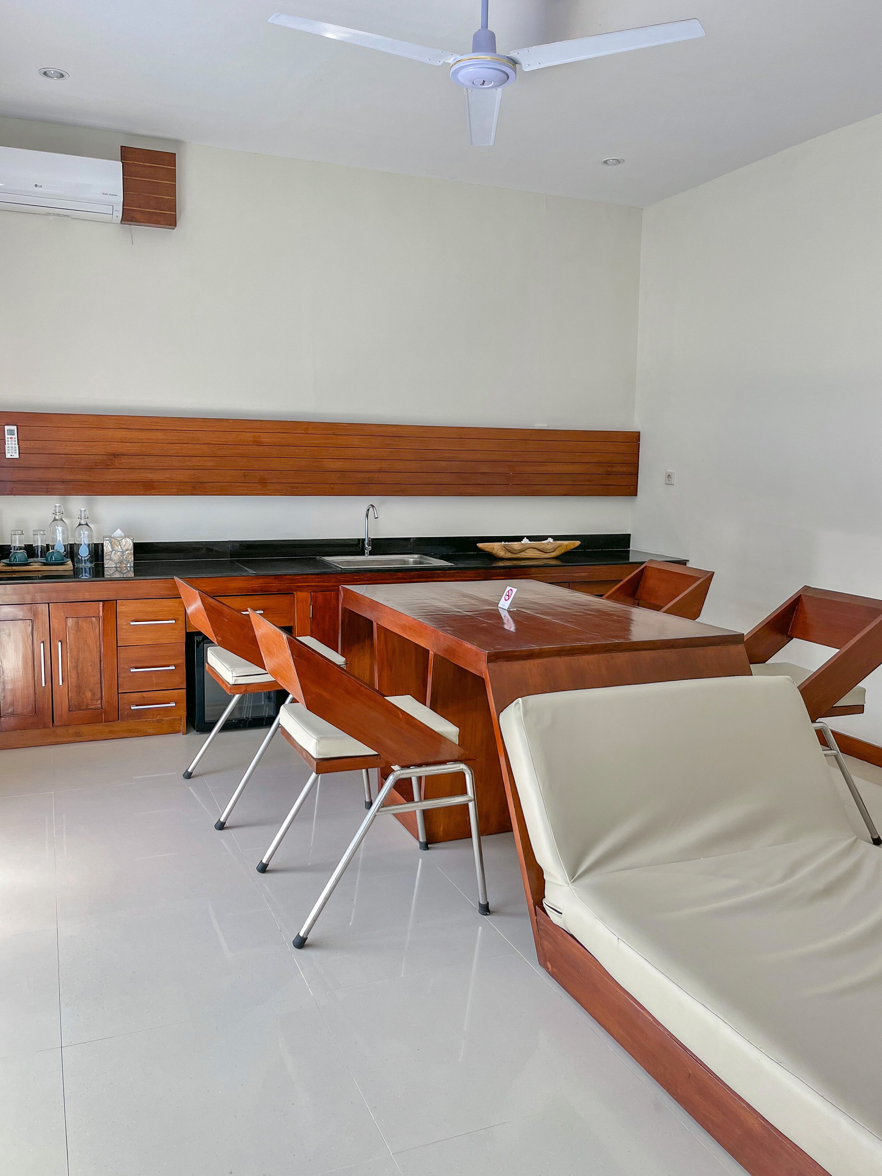 A modern kitchen with a wooden countertop, a built-in sink, and a ceiling fan.