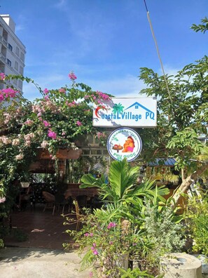 A sign for CostaL Village PQ with a logo for Oriander Kitchen PHU QUOC. - Coastal Village PQ (Phu Quoc)