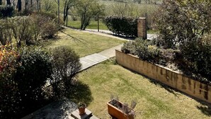 Um jardim com vista para colinas ondulantes e um céu claro.