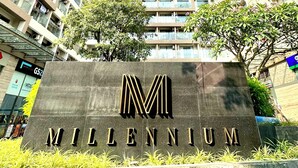 A high-rise building with a sign reading "MILLENNIUM" in front.