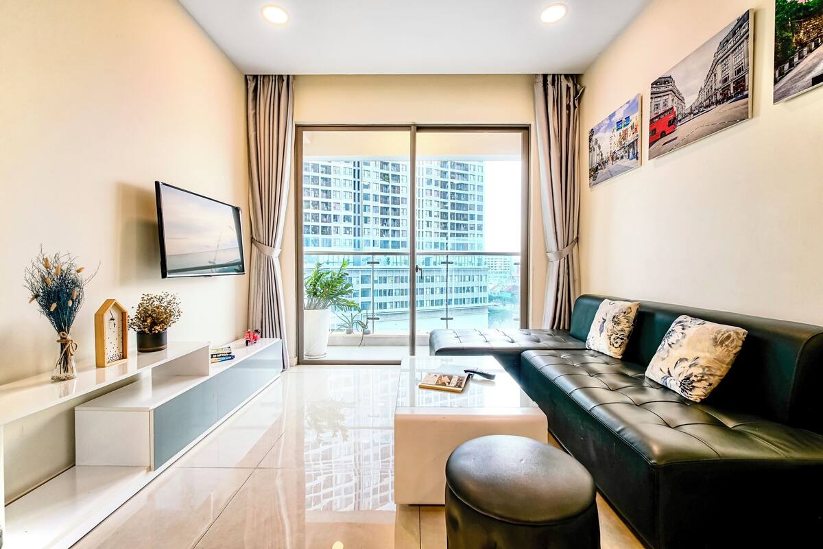 A modern living room with a sofa, a coffee table, and a TV on a wall.