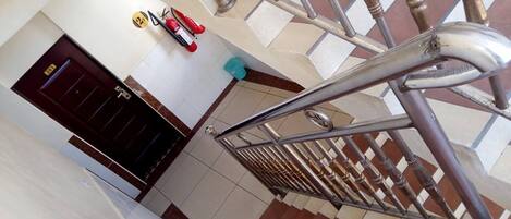 A staircase with metal railings and a tiled floor.