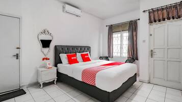 A neatly arranged bedroom with a bed, bedside table, and a mirror.