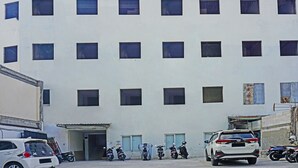 A multi-story building with a flat facade and multiple windows. - OYO 91455 New Hotelo (Jakarta)