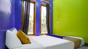 A single-bed room with a white bed, a yellow pillow, and a patterned blanket. - OYO Homes 90916 Eco Tourism Geopark Rajamandala Homestay Syariah (Rajamandala Kulon)