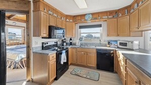 A kitchen with wooden cabinets, a stove, a microwave, and a dishwasher.
