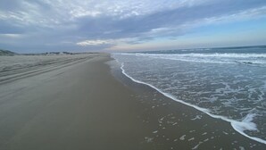 A beach with a wide sandy shore and gentle waves.