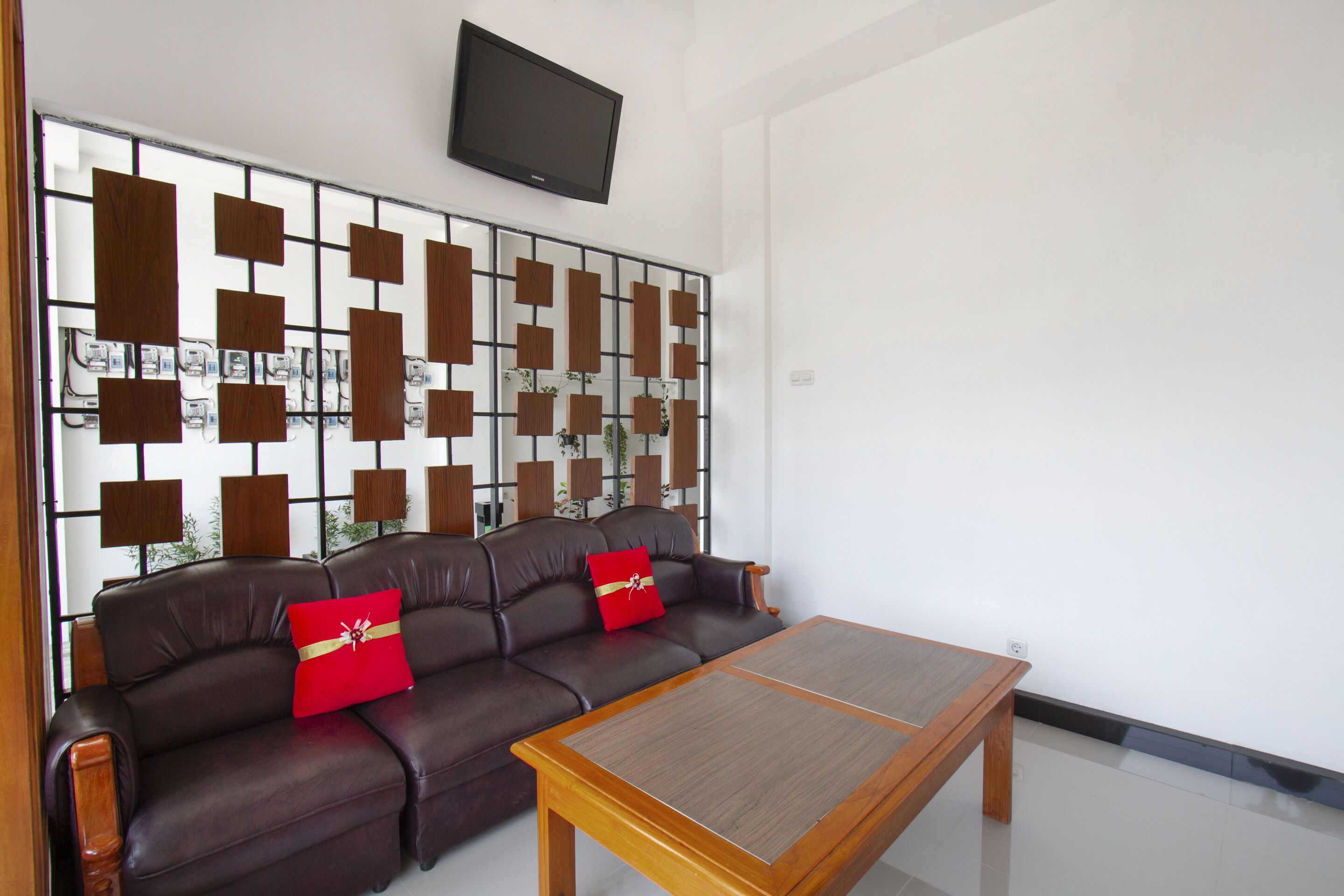 Una sala moderna con un sofá de cuero, una mesa de centro de madera y un panel decorativo en la pared.