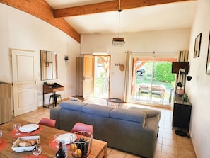Een gezellige woonkamer met een bank, eettafel en een keukenhoek.