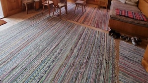 Ein traditioneller japanischer Raum mit Tatami-Böden, einem niedrigen Tisch mit Stühlen, einer Bank und einem Futon.