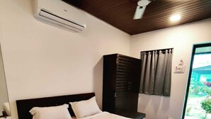 A bedroom with a bed, a wardrobe, an air conditioning unit, a ceiling fan, and a window with curtains. - Canal Touch Resort (Karjat)