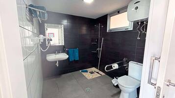 Un baño moderno con inodoro, lavamanos y ducha.