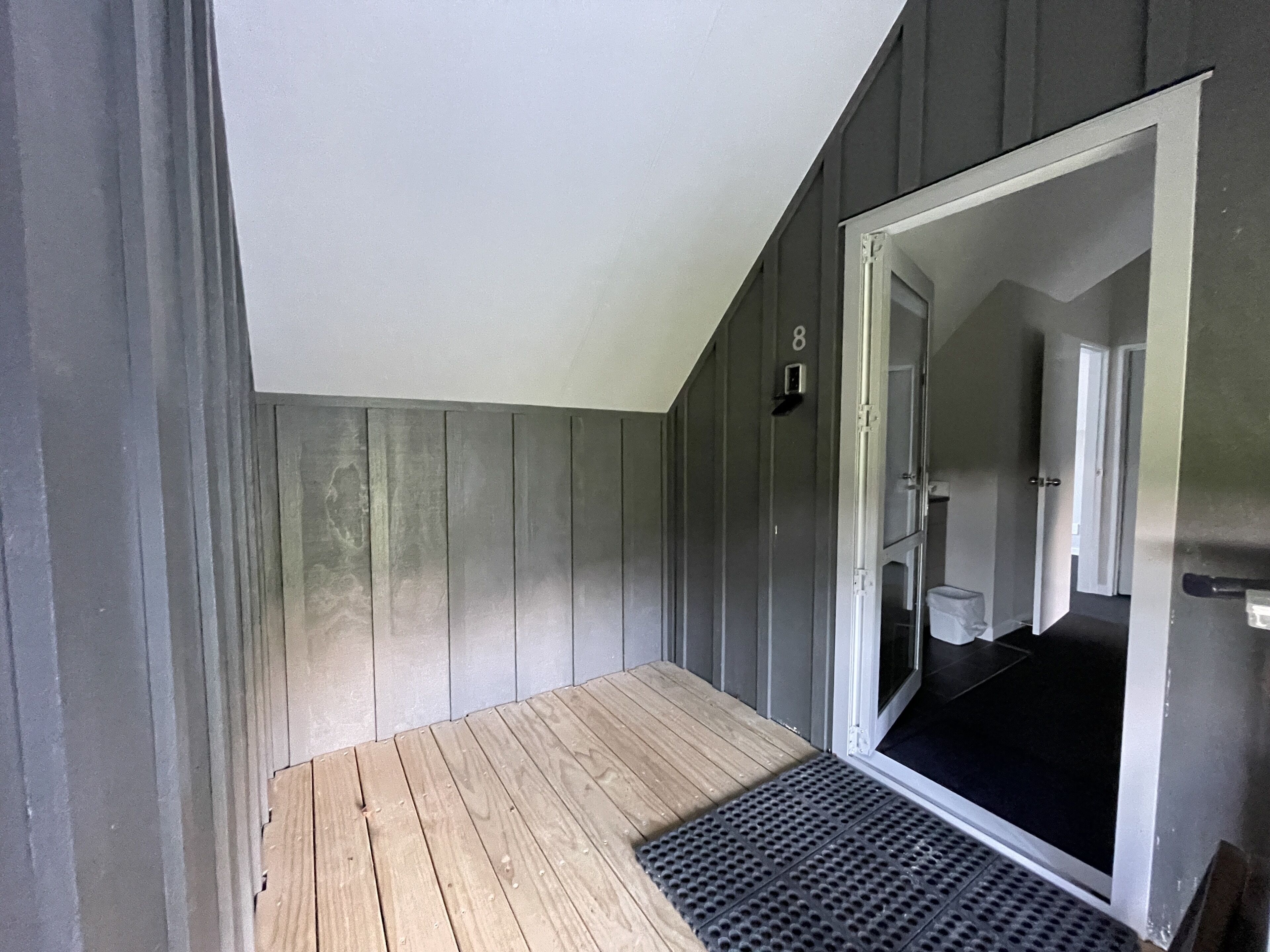 A small, narrow room with a wooden floor and a window.