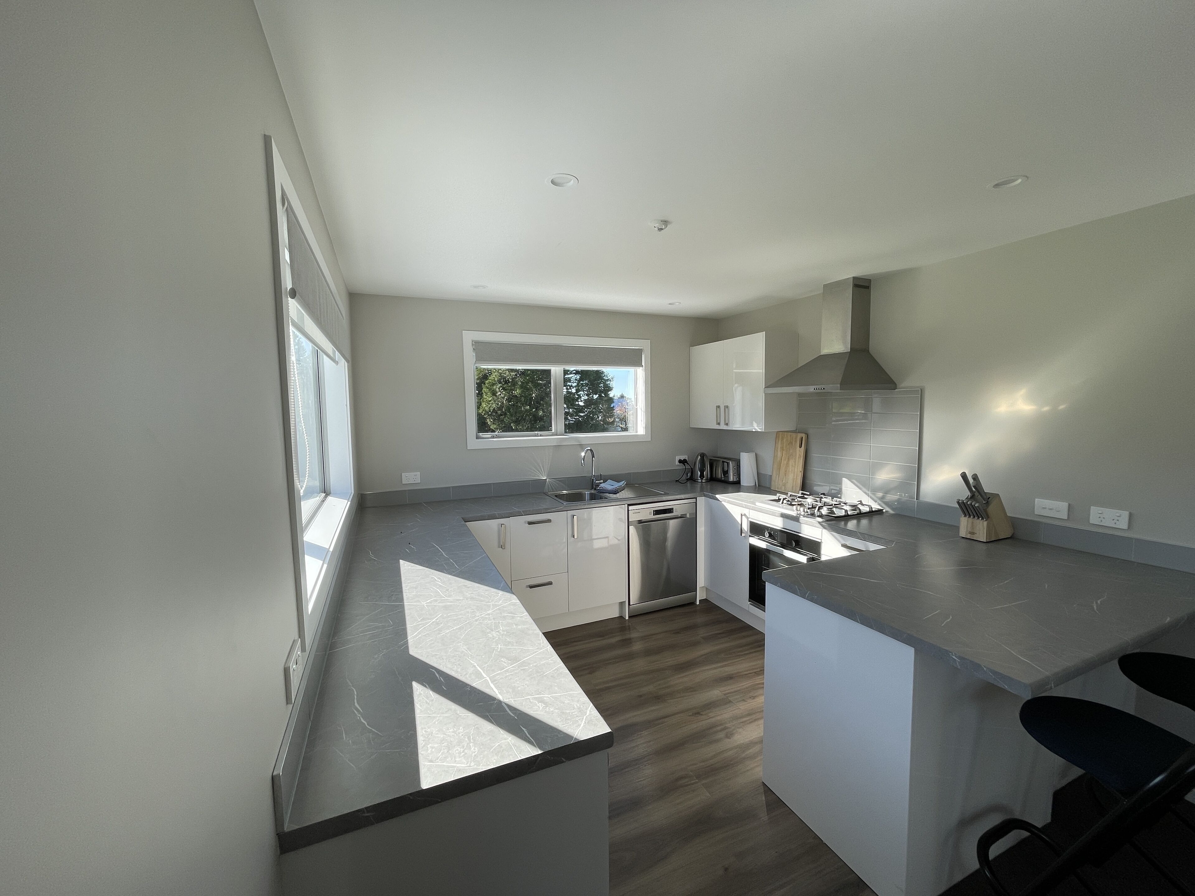 A modern kitchen with a built-in dishwasher, a gas stove, and a window providing natural light.