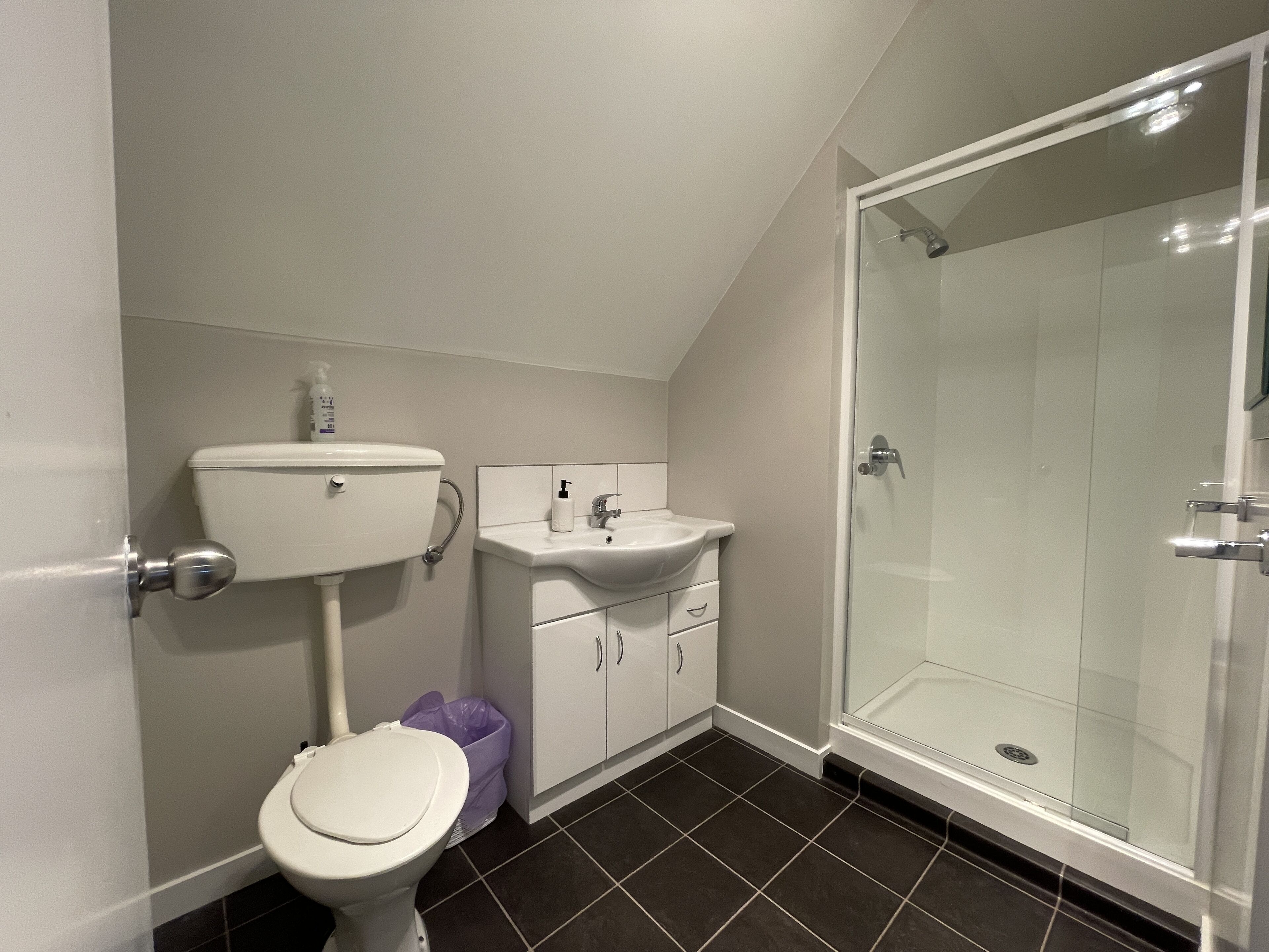 A bathroom with a toilet, sink, and shower.