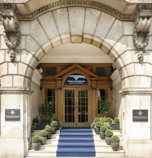 The entrance of Tower Residences with a blue carpeted staircase leading up to the doors. - Tower Residences by Blue Orchid (London)