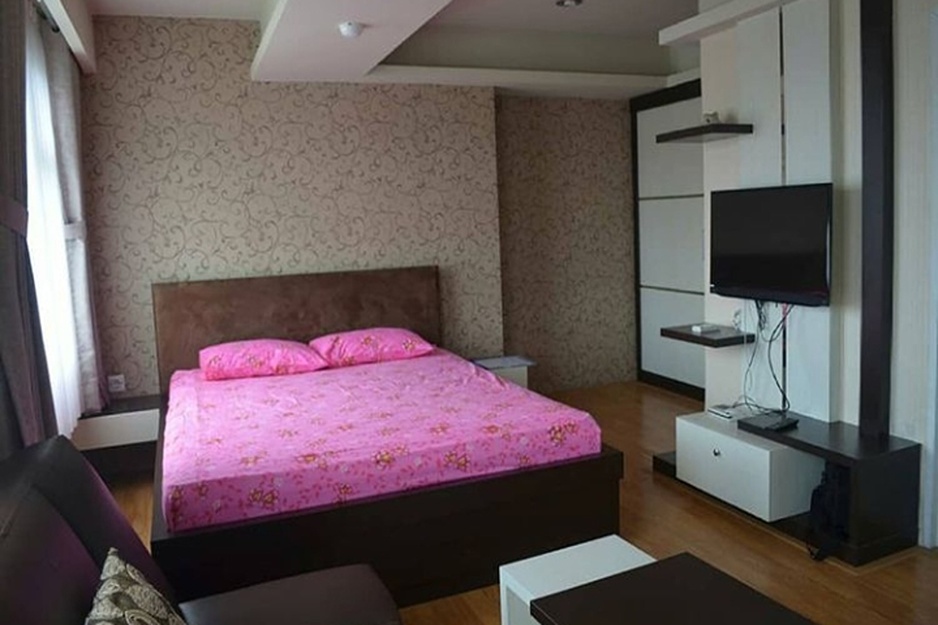 Una camera da letto con un letto, una televisione e un armadio.