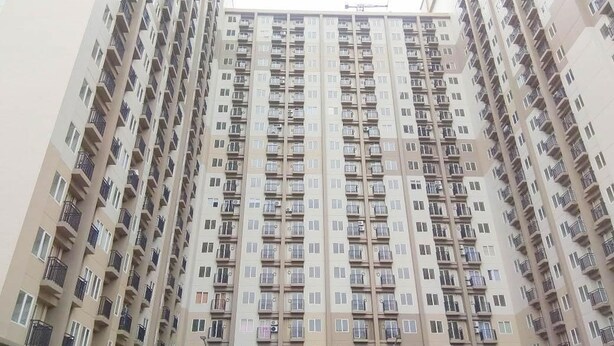 A high-rise residential building with multiple balconies and windows. - Room Rendi @ Podomoro Golf View (Gunung Putri)