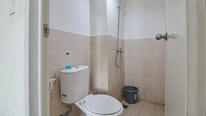 A small bathroom with a toilet, a shower, and a bucket. - Room Rendi @ Podomoro Golf View (Gunung Putri)