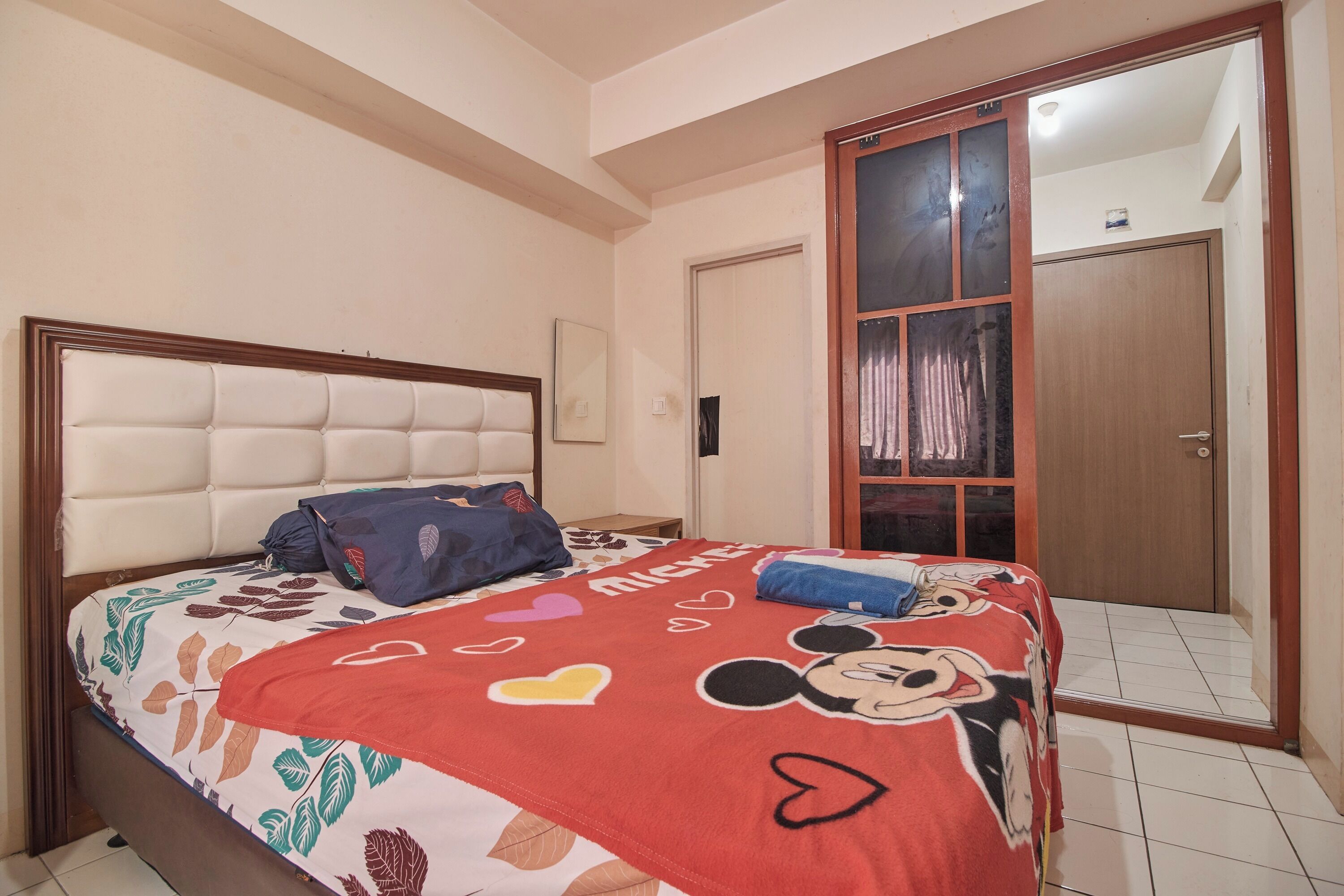 A bedroom with a bed, a wardrobe, and a door.