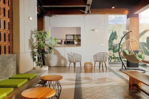 A modern interior with seating, a kitchen area, and a view of the outdoors.
