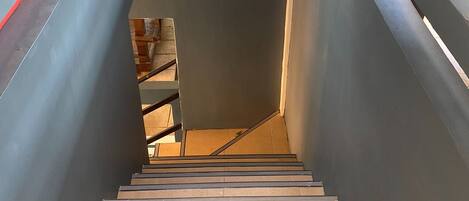 A modern staircase with metal railings and a dark wall.