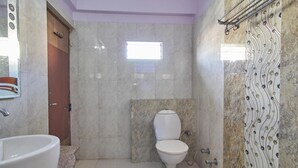 Un baño con bañera, inodoro y zona de ducha.