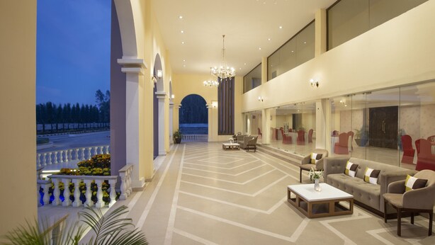 A spacious lobby with a modern design, featuring a seating area with sofas and a coffee table, a large chandelier, and a view of the outdoors. - Clarks Resort Birgunj (Birgunj)
