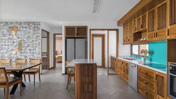 A modern kitchen with wooden cabinets, a central island, and a herringbone-patterned backsplash.