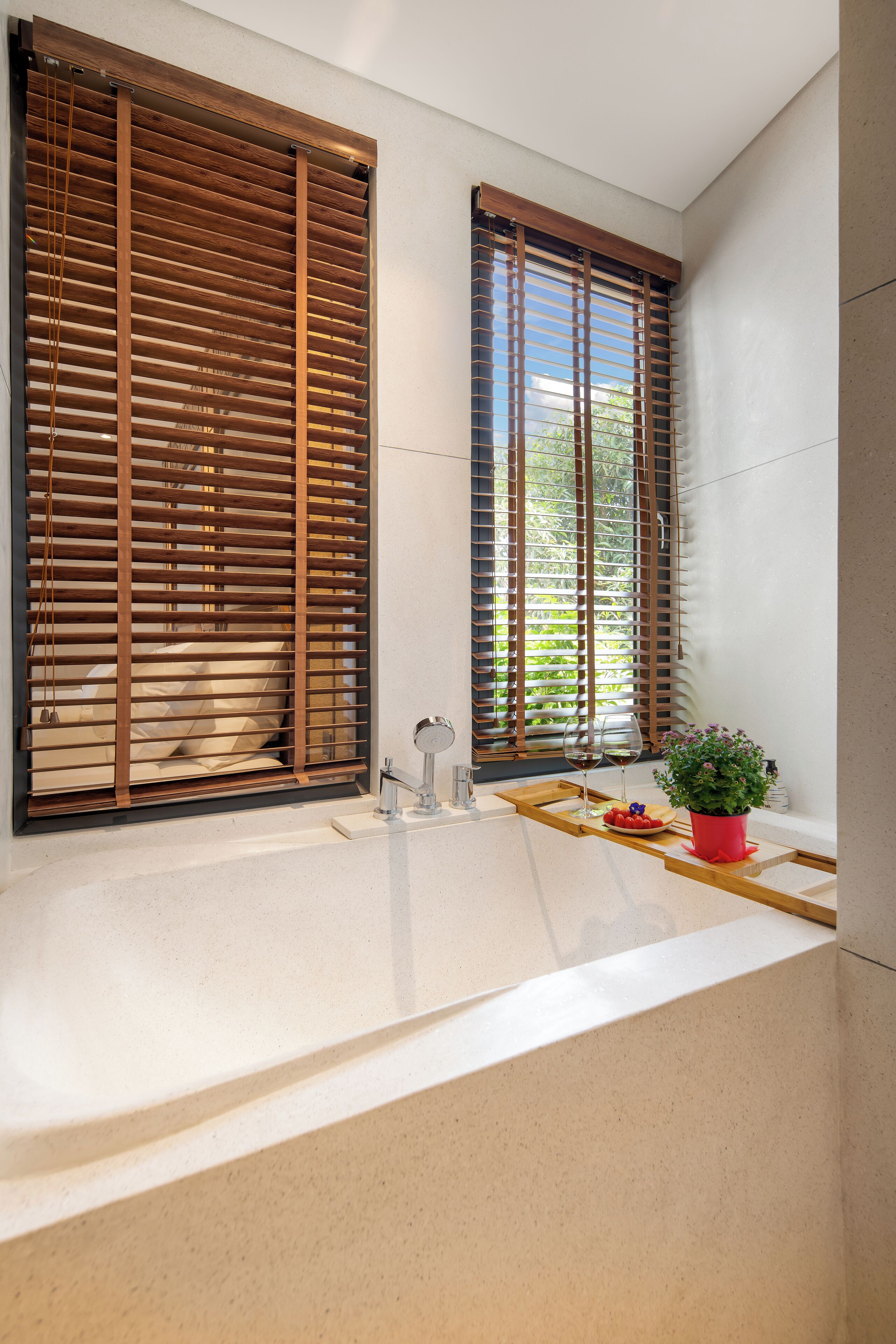 A bathroom with a large window, a sink, and a potted plant.