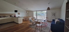 A modern apartment with a kitchen, dining area, and living room.