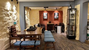 Un comedor acogedor con una mesa de madera, bancos y un fondo de pared de ladrillo.