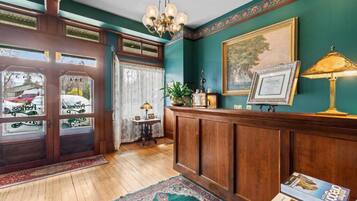 Ein traditionelles Interieur mit Holzvertäfelung, einem Chandelier und einem gerahmten Bild an der Wand.