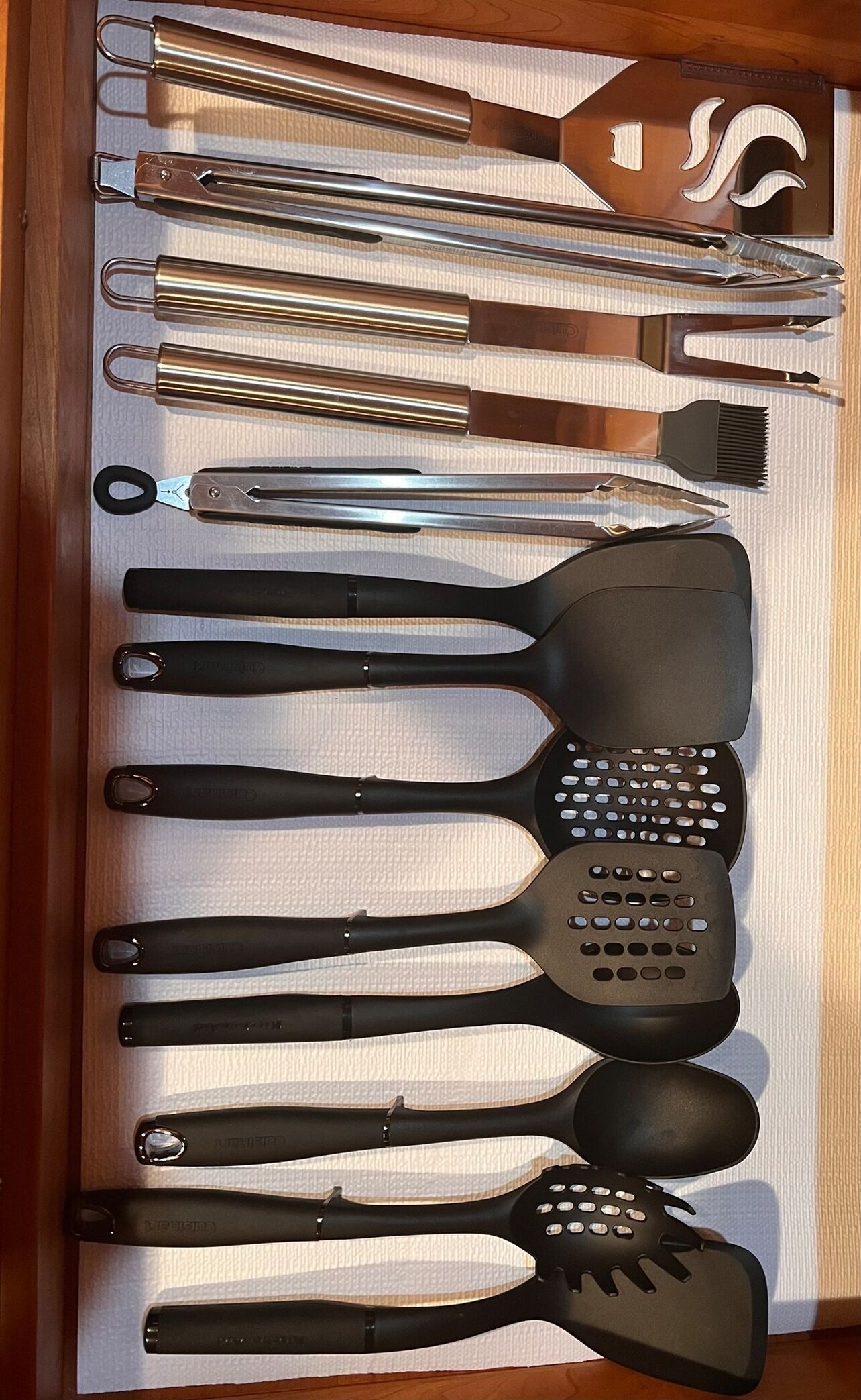 Un cajón con distintos utensilios de cocina, como espátulas, pinzas y un rallador.