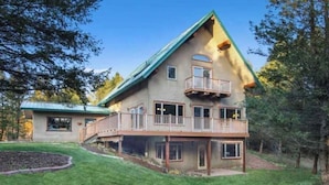 Une maison à deux étages avec un balcon et une véranda couverte.