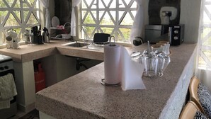 Una cocina con encimeras de granito, un lavabo y una cafetera.
